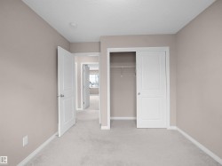 Unfurnished bedroom with light colored carpet, a closet, and a textured ceiling - 