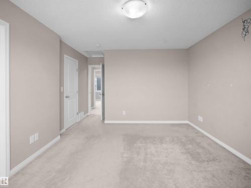 Unfurnished room featuring light carpet and a textured ceiling - 2080 Wonnacott Way, Edmonton, AB - Indoor Photo Showing Other Room