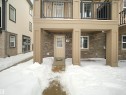 Snow covered property entrance featuring stone siding - 2080 Wonnacott Way, Edmonton, AB  - Outdoor With Balcony 