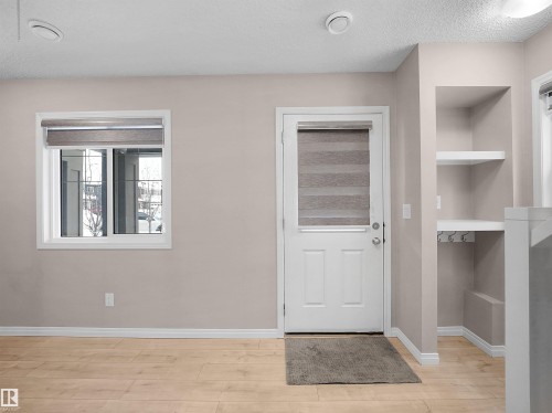 Entryway featuring a textured ceiling and light wood-type flooring - 2080 Wonnacott Way, Edmonton, AB - Indoor Photo Showing Other Room