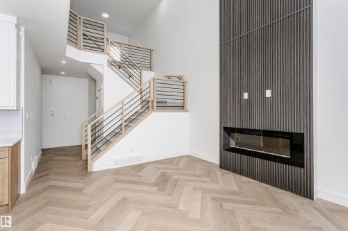 Unfurnished living room with a glass covered fireplace, recessed lighting, and stairway - 220 Edgemont Green Green, Edmonton, AB - Indoor Photo Showing Other Room With Fireplace