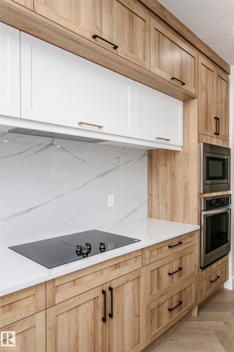 Kitchen featuring appliances with stainless steel finishes, light brown cabinetry, and light stone counters - 220 Edgemont Green Green, Edmonton, AB - Indoor Photo Showing Kitchen