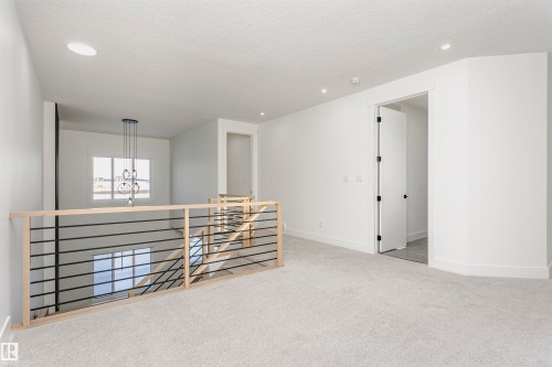Empty room with light carpet, recessed lighting, a chandelier, and a textured ceiling - 220 Edgemont Green Green, Edmonton, AB - Indoor
