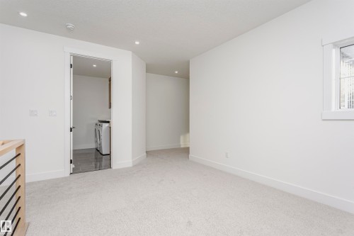 Unfurnished bedroom with light carpet, separate washer and dryer, recessed lighting, and a textured ceiling - 220 Edgemont Green Green, Edmonton, AB - Indoor Photo Showing Other Room