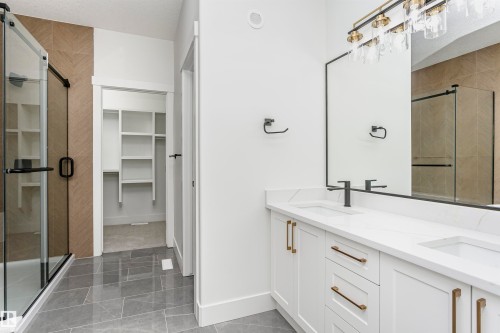 Full bath featuring a shower stall, double vanity, and a spacious closet - 220 Edgemont Green Green, Edmonton, AB - Indoor Photo Showing Bathroom