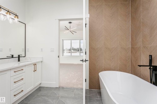 Full bathroom featuring a soaking tub, vanity, and light marble finish flooring - 220 Edgemont Green Green, Edmonton, AB - Indoor Photo Showing Bathroom