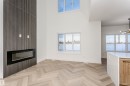 Unfurnished living room featuring a glass covered fireplace, a high ceiling, and a chandelier - 220 Edgemont Green Green, Edmonton, AB  - Indoor Photo Showing Other Room With Fireplace 