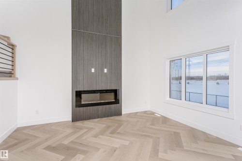 Unfurnished living room with a glass covered fireplace and a high ceiling - 220 Edgemont Green Green, Edmonton, AB - Indoor With Fireplace