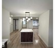 Unfurnished dining area with a textured ceiling and light wood-style floors - 11628 151 Avenue Nw, Edmonton, AB  - Indoor 