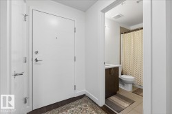 Bathroom featuring curtained shower, vanity, and dark wood-type flooring - 