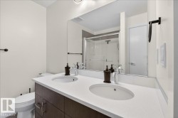 Bathroom featuring a stall shower and double vanity - 
