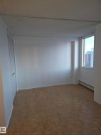 Empty room featuring a baseboard heating unit and baseboards - 