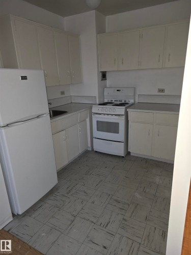 Kitchen with white appliances, light countertops, and white cabinets - 1402 9816 112 Street, Edmonton, AB - Indoor Photo Showing Kitchen