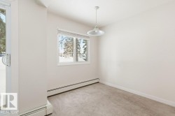Unfurnished room with a baseboard heating unit and light carpet - 