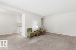 Living area featuring light carpet and a textured ceiling - 