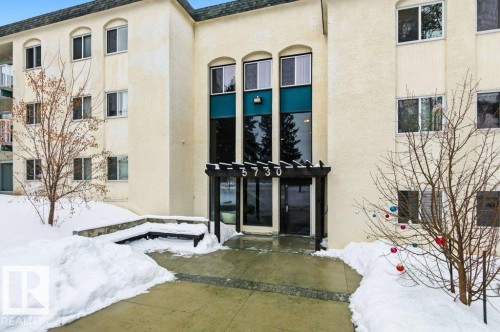 Doorway to property featuring a patio area, stucco siding, and roof with shingles - 124 5730 Riverbend Road, Edmonton, AB - Outdoor