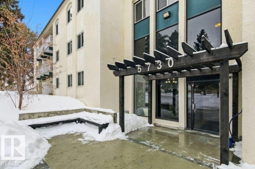 View of exterior entry featuring a pergola, stucco siding, and a patio - 124 5730 Riverbend Road, Edmonton, AB - Outdoor