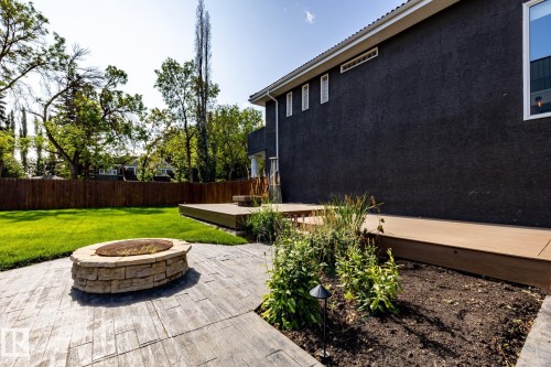 Fenced backyard with an outdoor fire pit and a wooden deck - 12428 103 Avenue, Edmonton, AB - Outdoor