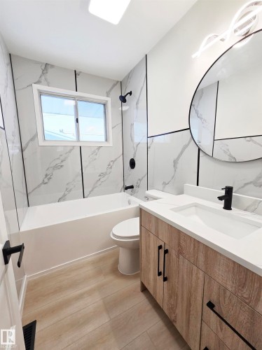 Bathroom featuring vanity and a combined bath / shower with marble appearance - 13711 133 Avenue, Edmonton, AB - Indoor Photo Showing Bathroom
