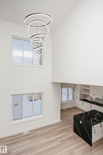 Living room featuring light wood-style flooring, a towering ceiling, and a chandelier - 804 Elderberry Crest, Edmonton, AB - Indoor Photo Showing Other Room