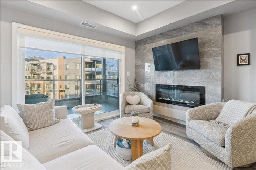 301 7463 May Common, Edmonton, AB - Indoor Photo Showing Living Room With Fireplace