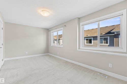 Unfurnished room featuring light colored carpet and a textured ceiling - 36 330 Bulyea Road, Edmonton, AB - Indoor Photo Showing Other Room