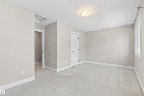 Unfurnished room with light carpet, a textured ceiling, and attic access - 36 330 Bulyea Road, Edmonton, AB - Indoor Photo Showing Other Room