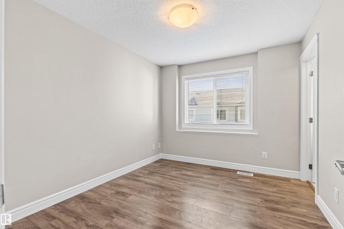 Unfurnished bedroom with wood finished floors and a textured ceiling - 36 330 Bulyea Road, Edmonton, AB - Indoor Photo Showing Other Room