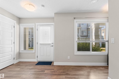 Foyer featuring a textured ceiling, healthy amount of natural light, and light wood-style floors - 36 330 Bulyea Road, Edmonton, AB - Indoor Photo Showing Other Room