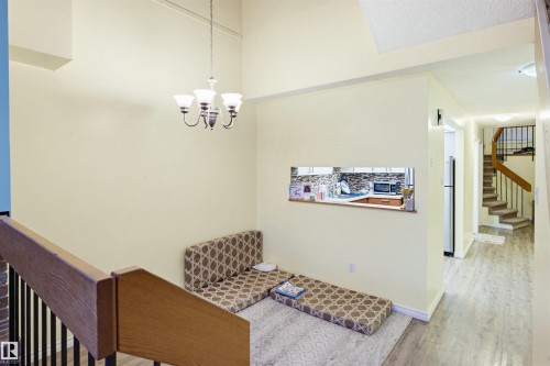 Entryway featuring wood finished floors, stairs, a chandelier, and a high ceiling - 11108 83 Avenue Nw, Edmonton, AB - Indoor