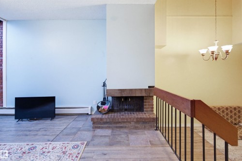 Interior space with baseboard heating, a chandelier, and a textured ceiling - 11108 83 Avenue Nw, Edmonton, AB - Indoor Photo Showing Other Room
