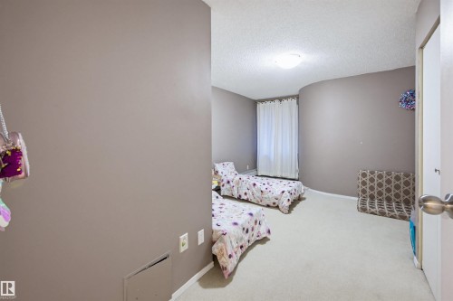 Bedroom with a textured ceiling and carpet floors - 11108 83 Avenue Nw, Edmonton, AB - Indoor