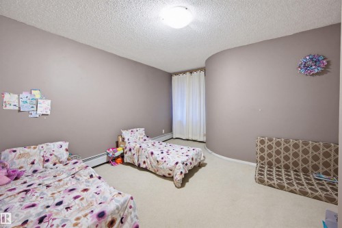 Bedroom featuring carpet floors, a textured ceiling, and baseboard heating - 11108 83 Avenue Nw, Edmonton, AB - Indoor Photo Showing Bedroom