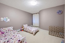 Bedroom featuring carpet floors, a textured ceiling, and baseboard heating - 