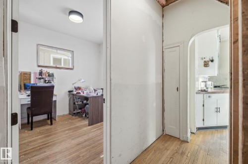 Corridor with light wood-style floors, a desk, and arched walkways - 11515 101 Street, Edmonton, AB - Indoor