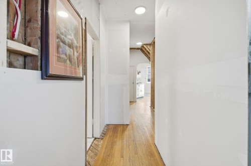 Hall with light wood-type flooring and arched walkways - 11515 101 Street, Edmonton, AB - Indoor Photo Showing Other Room