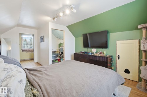 Bedroom featuring lofted ceiling, light wood finished floors, and rail lighting - 11515 101 Street, Edmonton, AB - Indoor Photo Showing Bedroom