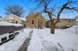 Snow covered back of property featuring stucco siding - 