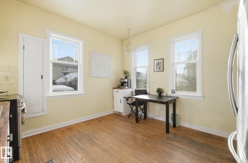 Office area with dark wood-style floors, healthy amount of natural light, and a chandelier - 11515 101 Street, Edmonton, AB - Indoor