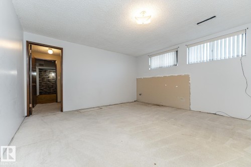 Below grade area with a textured ceiling and light carpet - 10207 165 Avenue, Edmonton, AB - Indoor