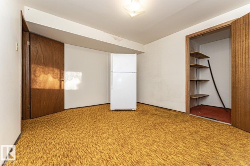 Unfurnished bedroom with freestanding refrigerator and carpet floors - 10207 165 Avenue, Edmonton, AB - Indoor Photo Showing Other Room