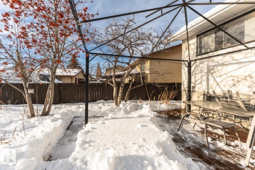 Yard layered in snow featuring a sunroom and outdoor dining space - 10207 165 Avenue, Edmonton, AB - Outdoor