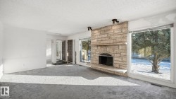 Unfurnished living room featuring a textured ceiling, carpet floors, and a fireplace - 