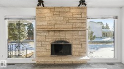 Detailed view of a textured ceiling, a stone fireplace, and carpet floors - 