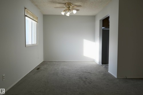 Carpeted empty room with ceiling fan and a textured ceiling - 10478 21 Avenue, Edmonton, AB - Indoor Photo Showing Other Room