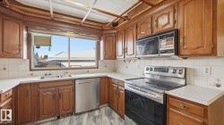 Kitchen with appliances with stainless steel finishes, tasteful backsplash, light countertops, and brown cabinetry - 