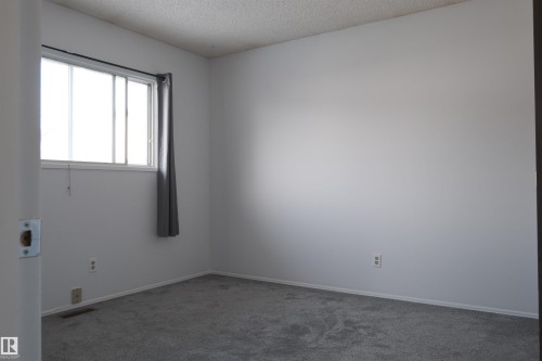 Unfurnished room featuring carpet flooring and a textured ceiling - 10478 21 Avenue, Edmonton, AB - Indoor Photo Showing Other Room