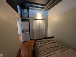 Bedroom with dark wood-type flooring, water heater, and a closet - 