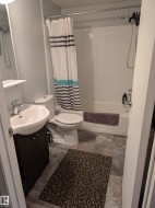 Full bath featuring vanity, shower / tub combo with curtain, and light stone finish flooring - 