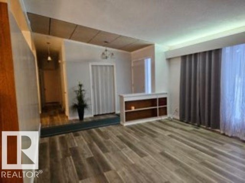 Unfurnished living room with wood finished floors and a chandelier - 4910 53 Avenue, Willingdon, AB 